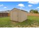 A backyard shed provides extra storage in a verdant yard with a privacy fence and a sunny sky above at 18396 E Mexico Pl, Aurora, CO 80017