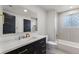 Modern bathroom featuring a stylish vanity, elegant mirror, bathtub, and designer fixtures at 18396 E Mexico Pl, Aurora, CO 80017
