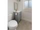 Modern bathroom with gray vanity, gold fixtures, and a tiled floor at 18396 E Mexico Pl, Aurora, CO 80017