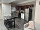 Kitchenette features a stainless steel refrigerator and a dining table with barstools at 10010 Columbine Ct, Thornton, CO 80229