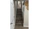 Staircase with wood-style steps and white railings, complemented by wall decor, providing a stylish transition between floors at 10010 Columbine Ct, Thornton, CO 80229