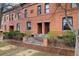 Attractive brick townhouse boasts a symmetrical facade, decorative iron fencing, and manicured landscaping at 1748 W 36Th Ave, Denver, CO 80211
