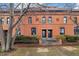 Charming brick townhouse featuring a symmetrical facade, iron fencing, and well-kept landscaping at 1748 W 36Th Ave, Denver, CO 80211