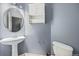 Cozy bathroom featuring pedestal sink, mirrored cabinet, and a toilet at 9484 E 108Th Ave, Commerce City, CO 80640
