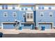 View of the garages of these townhomes with matching blue doors, siding, and white trim at 9484 E 108Th Ave, Commerce City, CO 80640