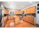 Spacious kitchen with wood cabinetry, stainless steel appliances, granite counters, and a central island at 1155 S Balsam St, Lakewood, CO 80232