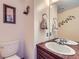 Powder room with a decorative mirror, vanity, artwork and lighting at 8862 E Amherst Dr # D, Denver, CO 80231