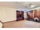 Carpeted basement living room featuring built-in shelving, a ceiling fan, and space for exercise at 8862 E Amherst Dr # D, Denver, CO 80231