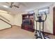 Basement living area with stairs, built-in shelving, carpeting, and exercise equipment at 8862 E Amherst Dr # D, Denver, CO 80231