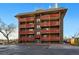 Multi-story brick apartment building with red balconies and ample parking in a convenient location at 3047 W 47Th Ave # 112, Denver, CO 80211
