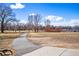 Scenic park view with paved path, trees, lake, and blue sky creating a tranquil and inviting outdoor space at 3047 W 47Th Ave # 112, Denver, CO 80211