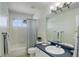 Bathroom featuring white tiled walls, a shower and tub combination, and a blue vanity with sink and mirror at 6527 Torrey Ct, Arvada, CO 80007