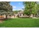 Spacious backyard with lush green lawn, mature trees, and detached garage at 113 S 4Th Ave, Brighton, CO 80601