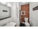 Charming bathroom with an exposed brick accent wall, modern sink with a mirror, and a toilet at 113 S 4Th Ave, Brighton, CO 80601