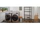 Convenient laundry room with modern washer and dryer, plus storage shelves and tiled floor at 113 S 4Th Ave, Brighton, CO 80601