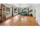 Sunlit living room boasting hardwood floors, large windows, and a comfortable teal sofa at 113 S 4Th Ave, Brighton, CO 80601