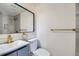 Modern bathroom featuring stylish gray vanity, gold fixtures, and a sleek mirror at 5050 Steele St, Denver, CO 80216