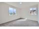 Bright carpeted bedroom with two windows offering ample natural light and neighborhood views at 5050 Steele St, Denver, CO 80216