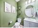 Stylish half bathroom features modern fixtures, elegant mirror, and olive green walls at 18103 House Finch Ln, Parker, CO 80134