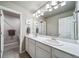 Bright bathroom featuring a double sink vanity with framed mirror, contemporary lighting, and tile flooring at 18103 House Finch Ln, Parker, CO 80134