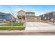 Charming two-story home with stone accents, three-car garage, manicured lawn, and inviting curb appeal at 18103 House Finch Ln, Parker, CO 80134