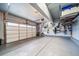 Organized two car garage with epoxy flooring, storage racks, and ample space for vehicles and tools at 18103 House Finch Ln, Parker, CO 80134
