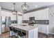 Modern white kitchen with stainless steel appliances, island and pendant lighting at 18103 House Finch Ln, Parker, CO 80134