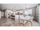Open-concept kitchen and dining area with white cabinets, stainless appliances, and modern lighting at 18103 House Finch Ln, Parker, CO 80134
