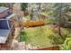 Large, grassy fenced backyard with mature trees and a patio area at 10866 W Half Moon Pass, Littleton, CO 80127