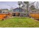 Spacious backyard with covered patio, wood pile, and well-manicured lawn at 10866 W Half Moon Pass, Littleton, CO 80127