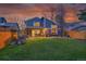 Backyard featuring a covered patio with dining area, a wood pile, and a lush lawn at 10866 W Half Moon Pass, Littleton, CO 80127