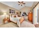 Cozy bedroom with a wooden bed frame, soft carpet, vaulted ceilings, and a barn-style door at 10866 W Half Moon Pass, Littleton, CO 80127
