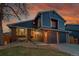 Charming two-story home with a brick and siding exterior and a two-car garage, showcasing its curb appeal at 10866 W Half Moon Pass, Littleton, CO 80127