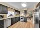 Modern kitchen with stainless steel appliances, granite countertops, and wood-look floors at 10866 W Half Moon Pass, Littleton, CO 80127