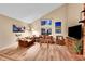 Bright living room featuring high ceilings, wood flooring, comfortable seating, and natural light at 10866 W Half Moon Pass, Littleton, CO 80127