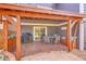 Covered patio area features wooden beams, a grill, and outdoor seating overlooking a nice backyard at 10866 W Half Moon Pass, Littleton, CO 80127