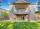 Exterior view of a house with a spacious deck above a covered patio and a lush green lawn at 24955 E Roxbury Pl, Aurora, CO 80016