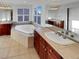 Bright bathroom featuring double vanity, large tub, and tile flooring at 24955 E Roxbury Pl, Aurora, CO 80016