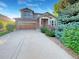 Charming two-story home featuring a stone facade, wood garage door, well maintained landscaping, and inviting entrance at 24955 E Roxbury Pl, Aurora, CO 80016