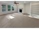Spacious living room with a cozy fireplace, built-in shelving, large windows, and neutral carpeting at 24955 E Roxbury Pl, Aurora, CO 80016