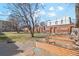 Landscaped backyard with brick and stone path, raised garden beds, and mature trees at 1581 N Ogden St, Denver, CO 80218