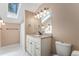 Bathroom featuring white vanity, granite counters, and a skylight for natural light at 34498 Forest Estates Rd, Evergreen, CO 80439