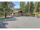 Charming home featuring an expansive driveway and basketball hoop with lush landscaping and a multi-car garage at 34498 Forest Estates Rd, Evergreen, CO 80439