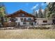 Inviting home exterior with stone accents, a balcony, and a well-maintained lawn creating curb appeal at 34498 Forest Estates Rd, Evergreen, CO 80439