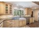 Bright kitchen with large sink, mosaic backsplash, and view of evergreen trees at 34498 Forest Estates Rd, Evergreen, CO 80439