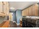 Spacious laundry area featuring plentiful cabinet space, blue walls, and wood plank flooring at 34498 Forest Estates Rd, Evergreen, CO 80439