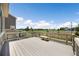 A spacious back deck overlooking green fields, a white fence, and a bench at 985 Penstemon Dr, Henderson, CO 80640
