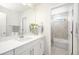 Bright bathroom featuring a vanity with a sink, a large mirror, and an adjacent tiled shower over tub at 985 Penstemon Dr, Henderson, CO 80640