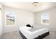Simple bedroom with natural light from two windows with a bed frame at 985 Penstemon Dr, Henderson, CO 80640