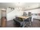 Dining area with a rustic wooden table and a modern chandelier at 985 Penstemon Dr, Henderson, CO 80640